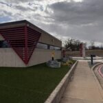 Building Exterior With Modern Design And Artificial Turf Landscaping Under Cloudy Sky