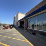 pane fully clean conducting window cleaning using a long pole and cleaning solution on a commercial building exterior