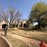residential area with well-maintained landscaping and a stone house no visible cleaning activity in the immediate view